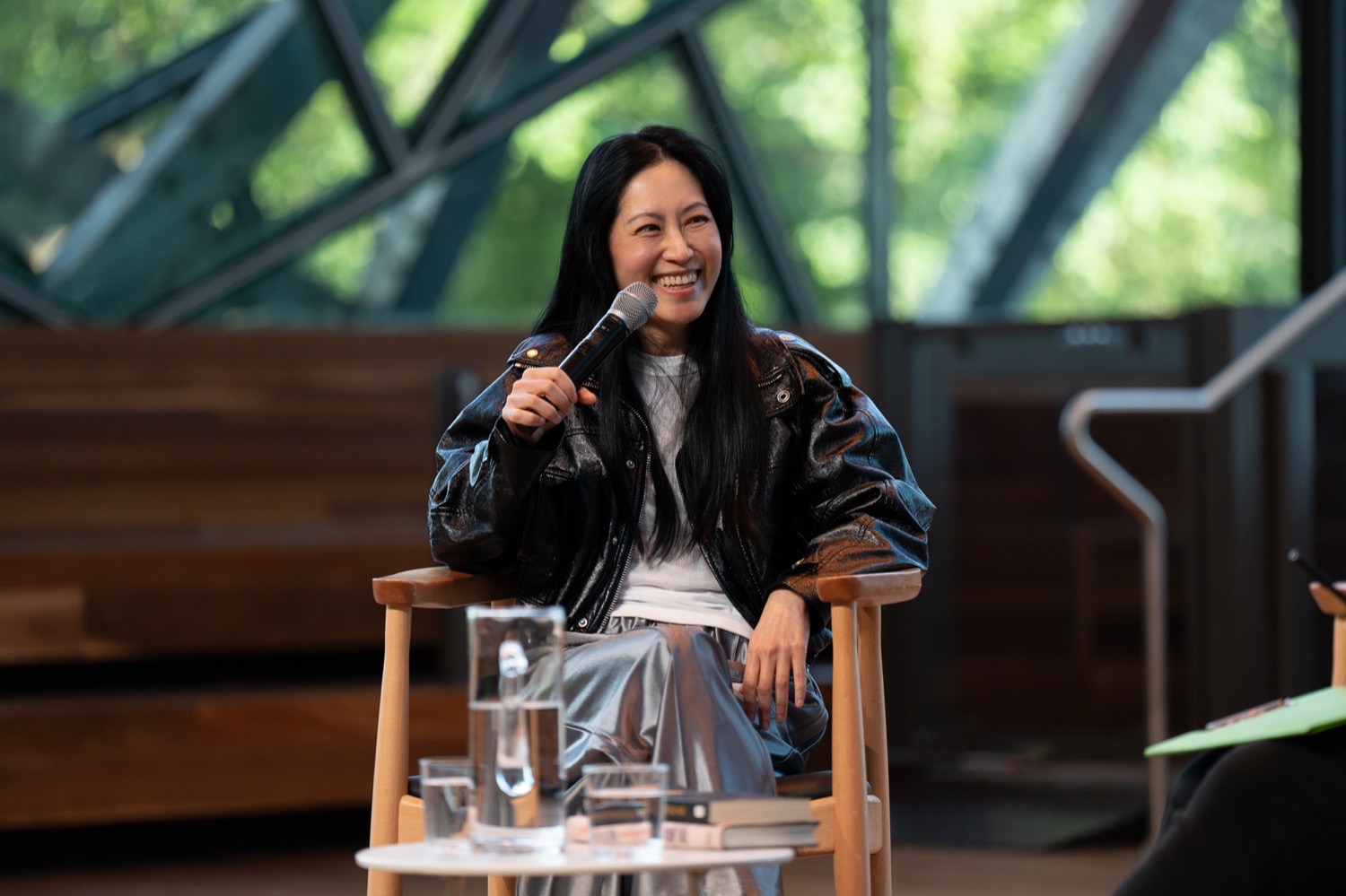 Monica Lim speaking with a microphone during an in-conversation event